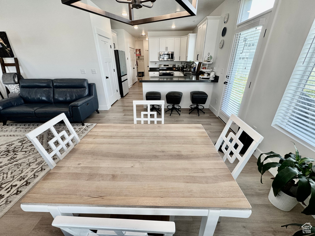 Dining area with light wood-type flooring and recessed lighting