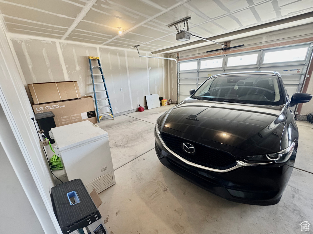 Garage with a garage door opener and fridge