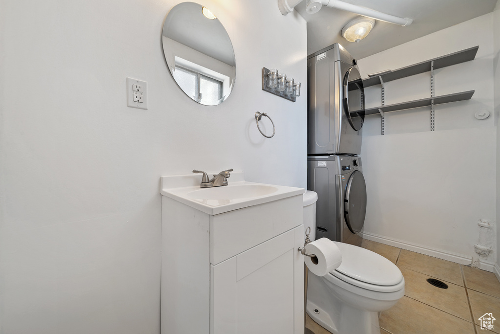 Bathroom featuring estacked washer and dryer, vanity, and tile patterned flooring