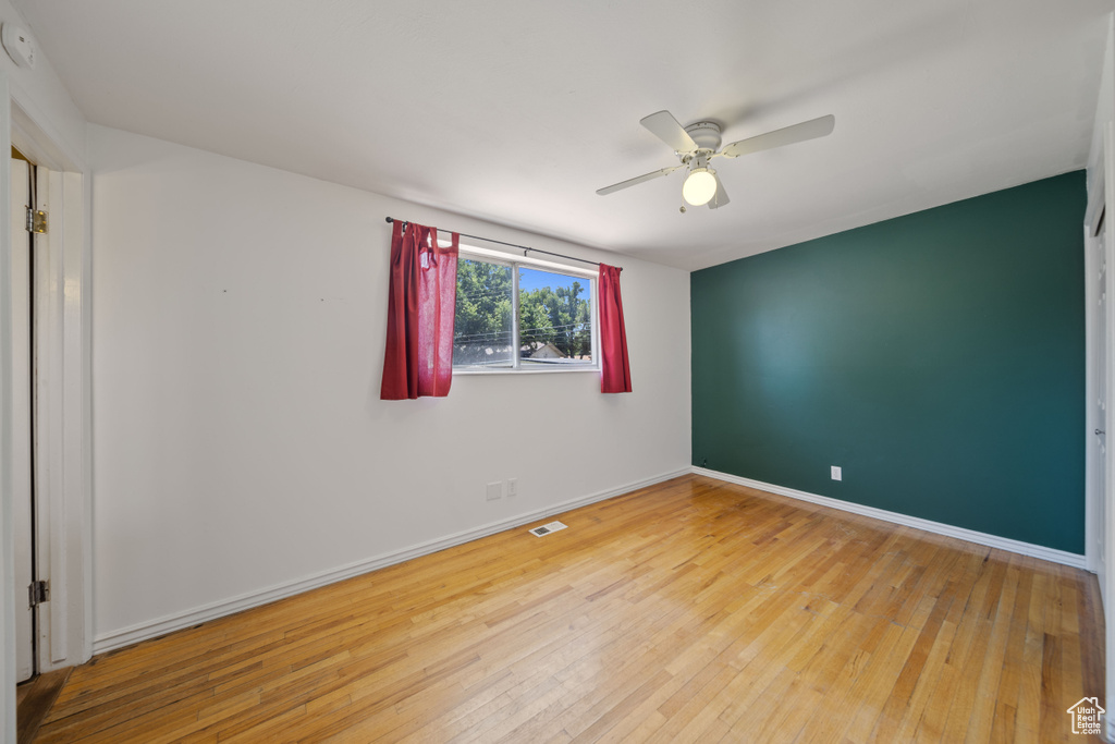 Unfurnished room with hardwood / wood-style flooring and a ceiling fan