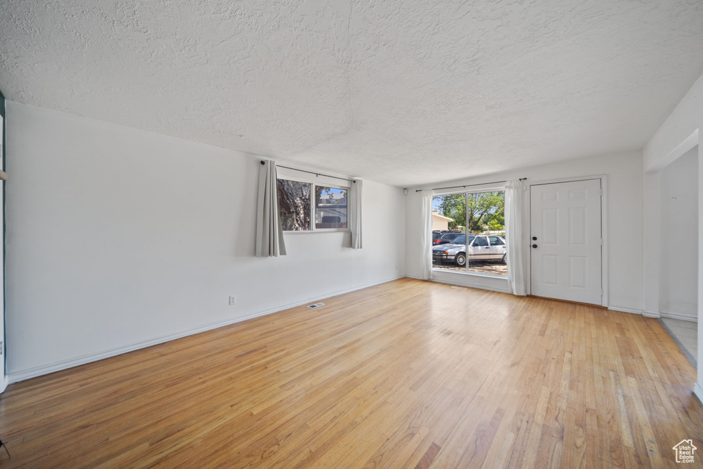 Spare room with a textured ceiling and hardwood / wood-style flooring