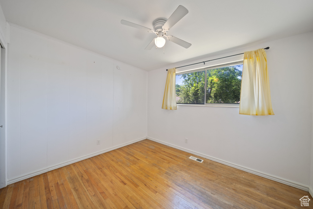 Unfurnished room featuring hardwood / wood-style flooring and a ceiling fan