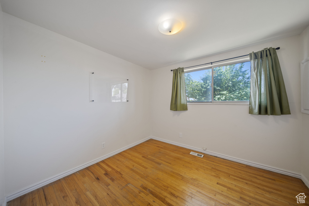 Spare room featuring healthy amount of natural light and light wood-type flooring