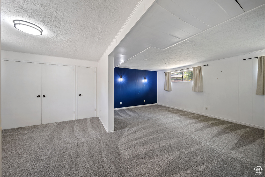 Below grade area with carpet floors and a textured ceiling