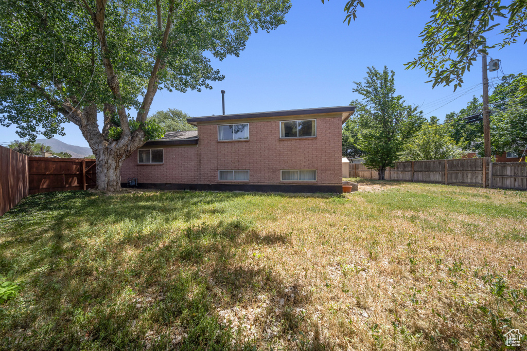 Rear view of property featuring a fenced backyard and brick siding