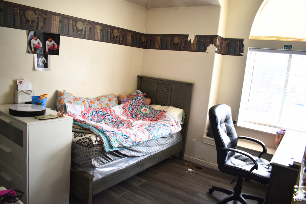 Bedroom with dark wood finished floors and a desk