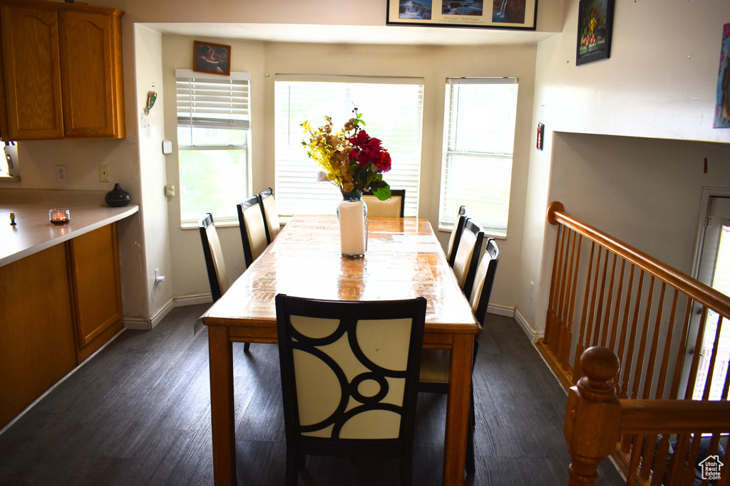Dining space featuring dark wood-type flooring and baseboards