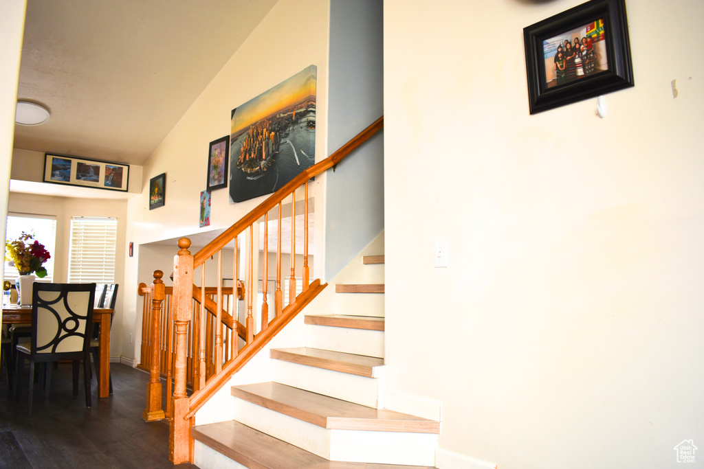 Staircase featuring wood finished floors and a high ceiling