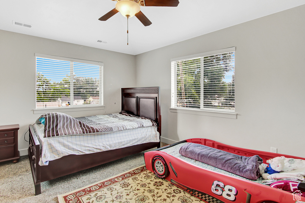 Bedroom featuring a ceiling fan and carpet