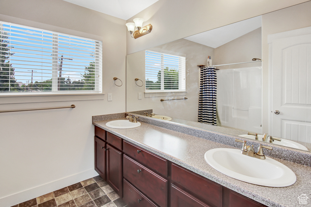 Full bathroom with double vanity and a shower with curtain