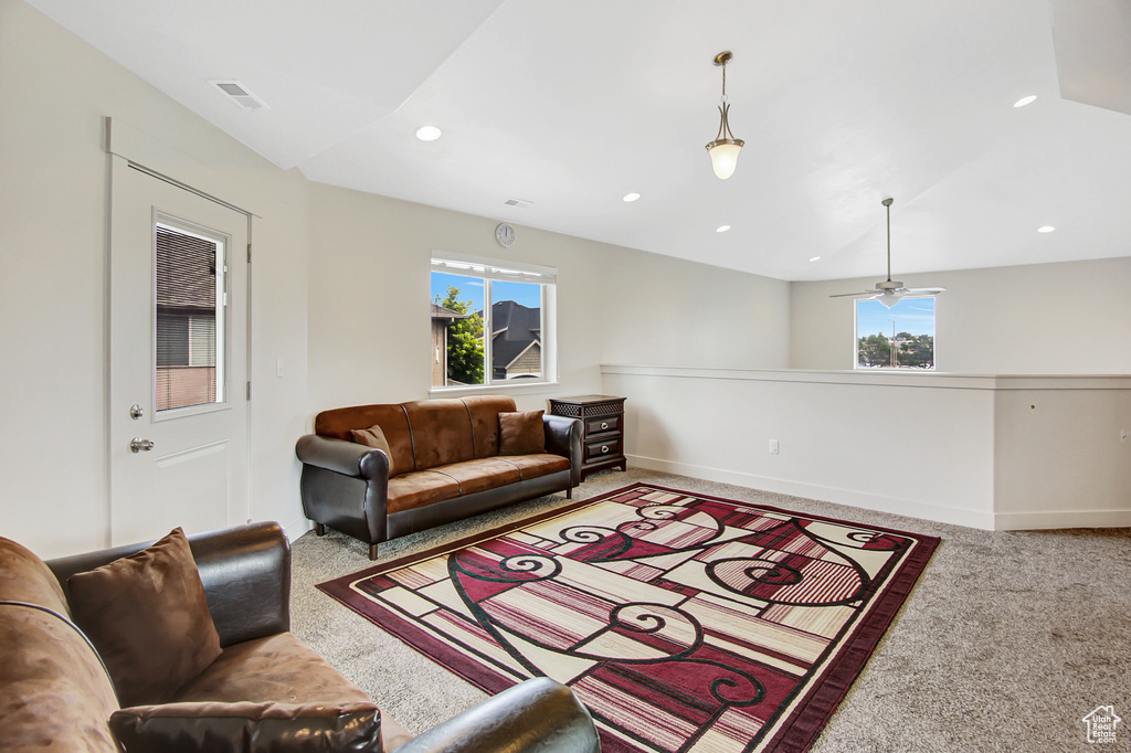Carpeted living room with recessed lighting and a ceiling fan