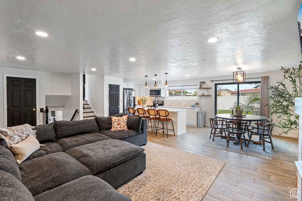Living area featuring light wood-style flooring, recessed lighting, and stairs