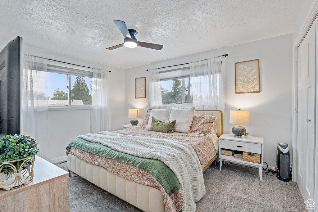 Bedroom featuring carpet floors, a closet, ceiling fan, and a textured ceiling