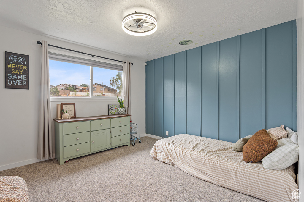 Bedroom featuring light colored carpet and a textured ceiling