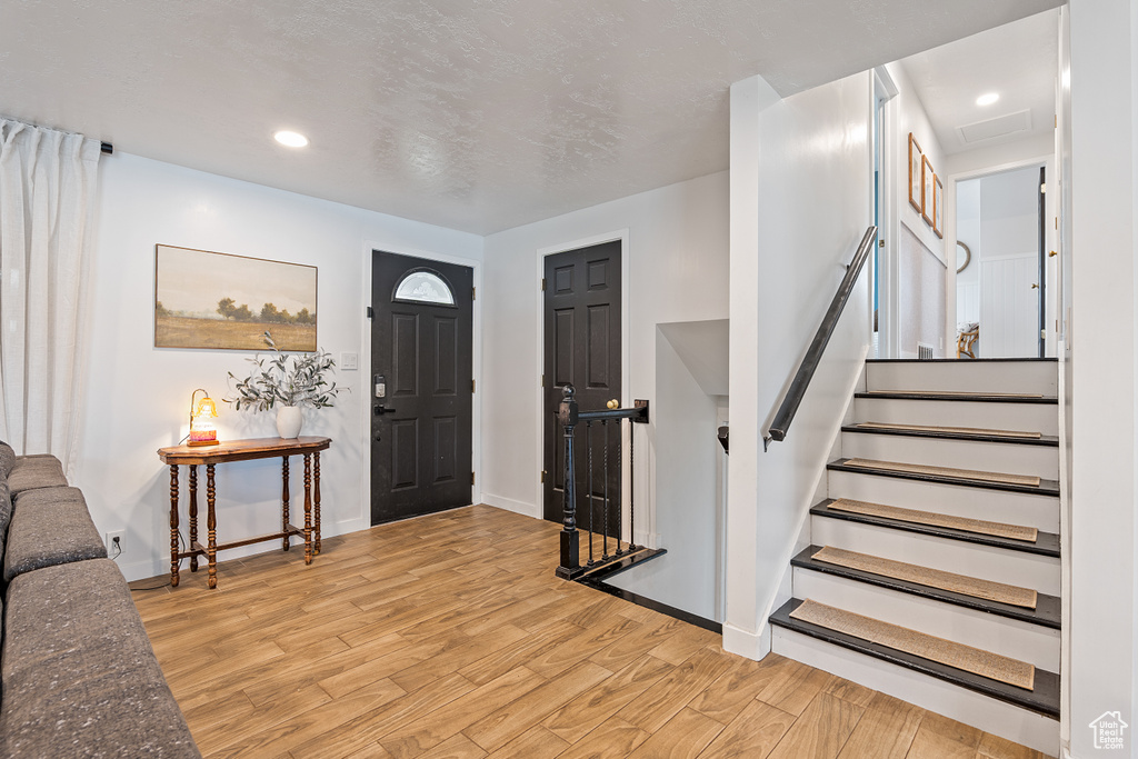 Foyer with light wood-type flooring and recessed lighting