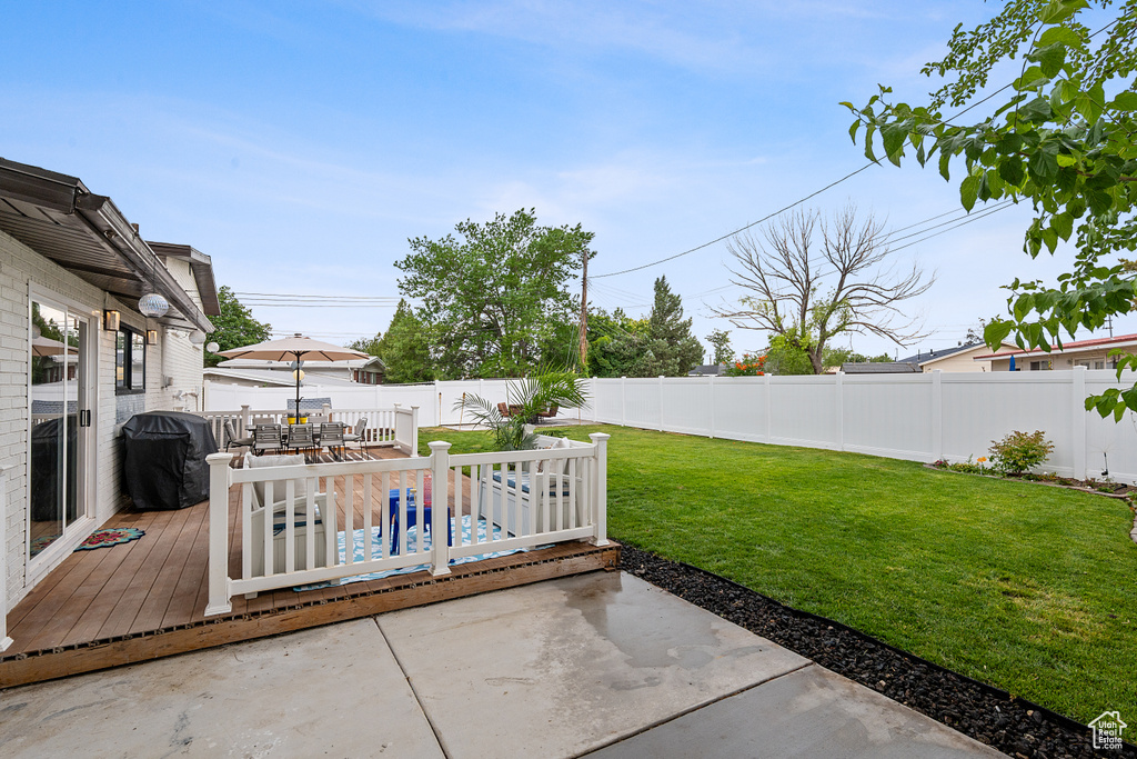 Fenced backyard with area for grilling, a patio, outdoor dining area, and a deck