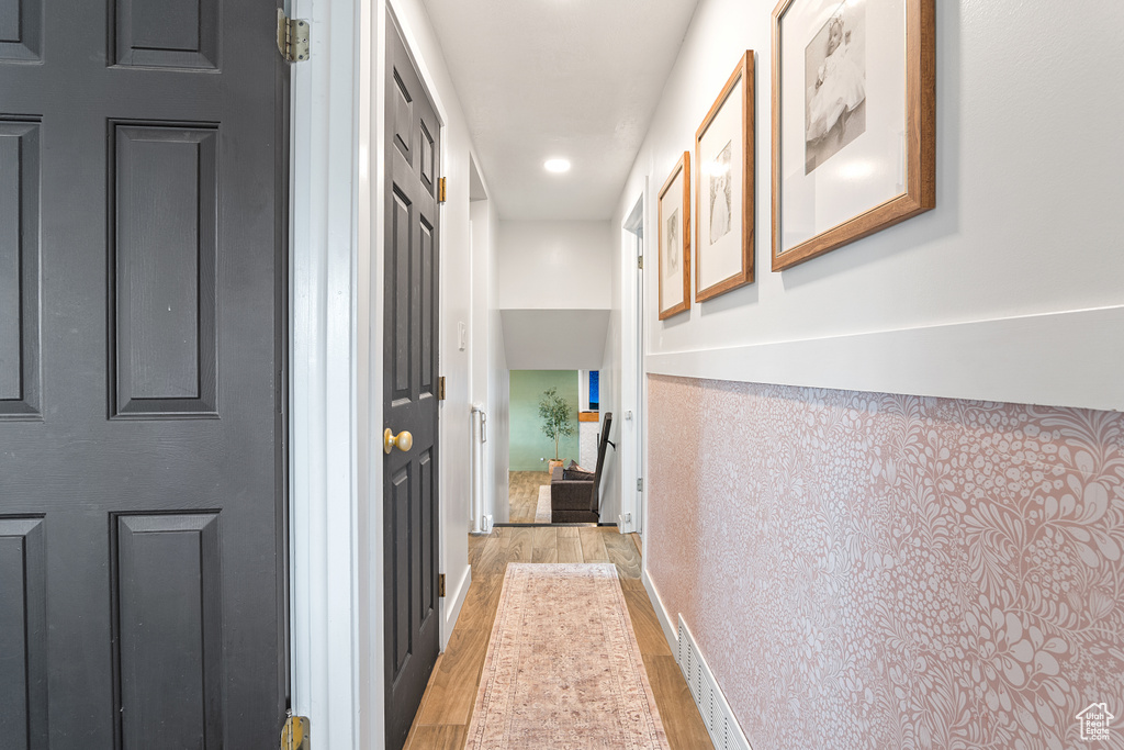 Corridor with light wood-style floors and recessed lighting