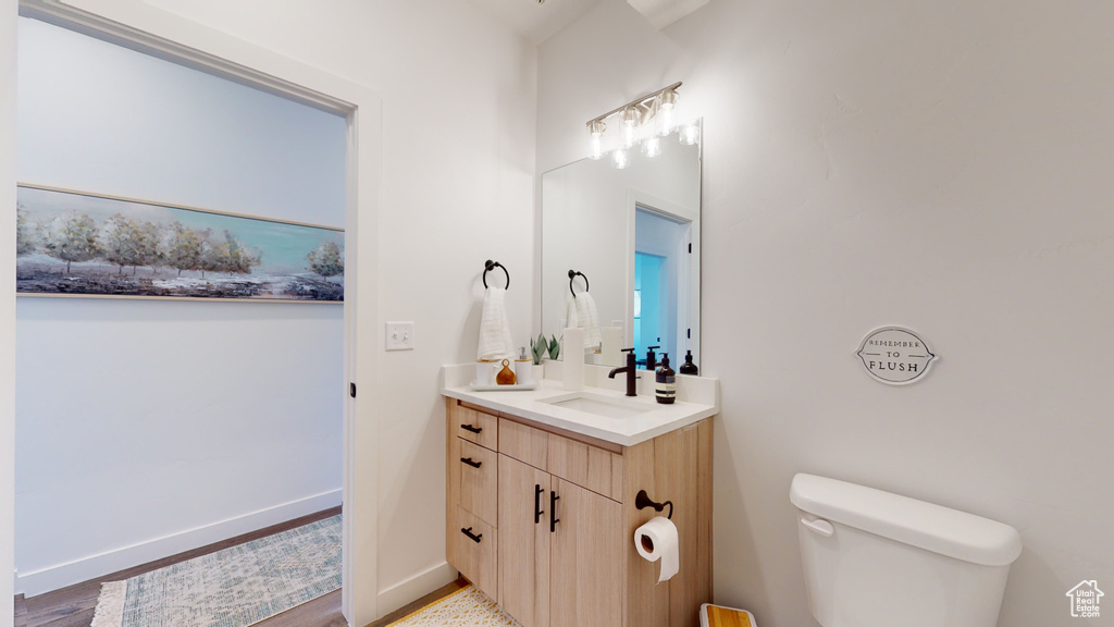 Half bathroom with vanity and wood finished floors
