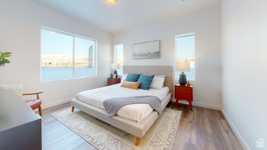 Bedroom with wood finished floors and baseboards