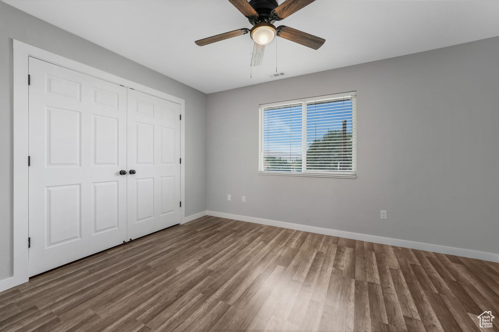 Unfurnished bedroom with wood finished floors, a closet, and ceiling fan