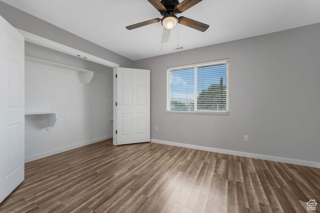 Unfurnished bedroom featuring wood finished floors and a ceiling fan