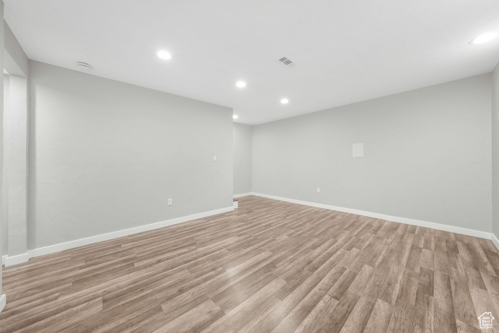Unfurnished room with light wood-style floors, recessed lighting, and a smoke detector
