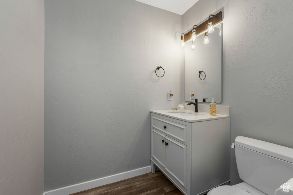 Half bath featuring vanity and wood finished floors
