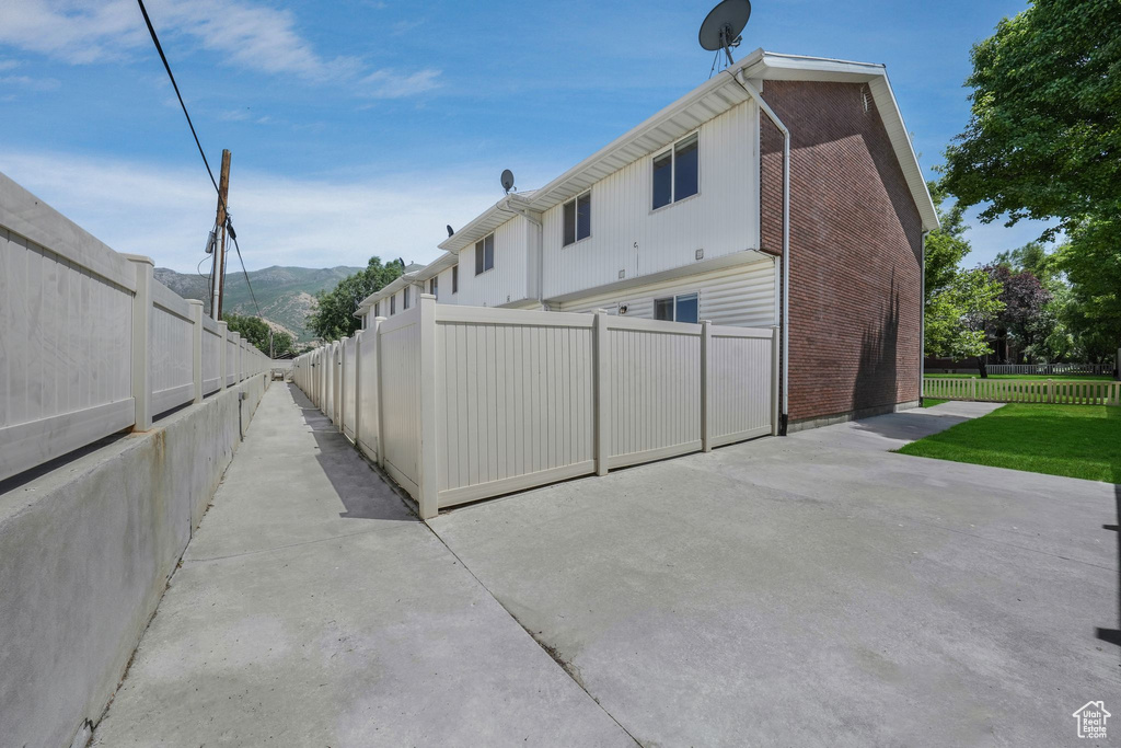 Back of house with a mountain view, a patio area, and brick siding