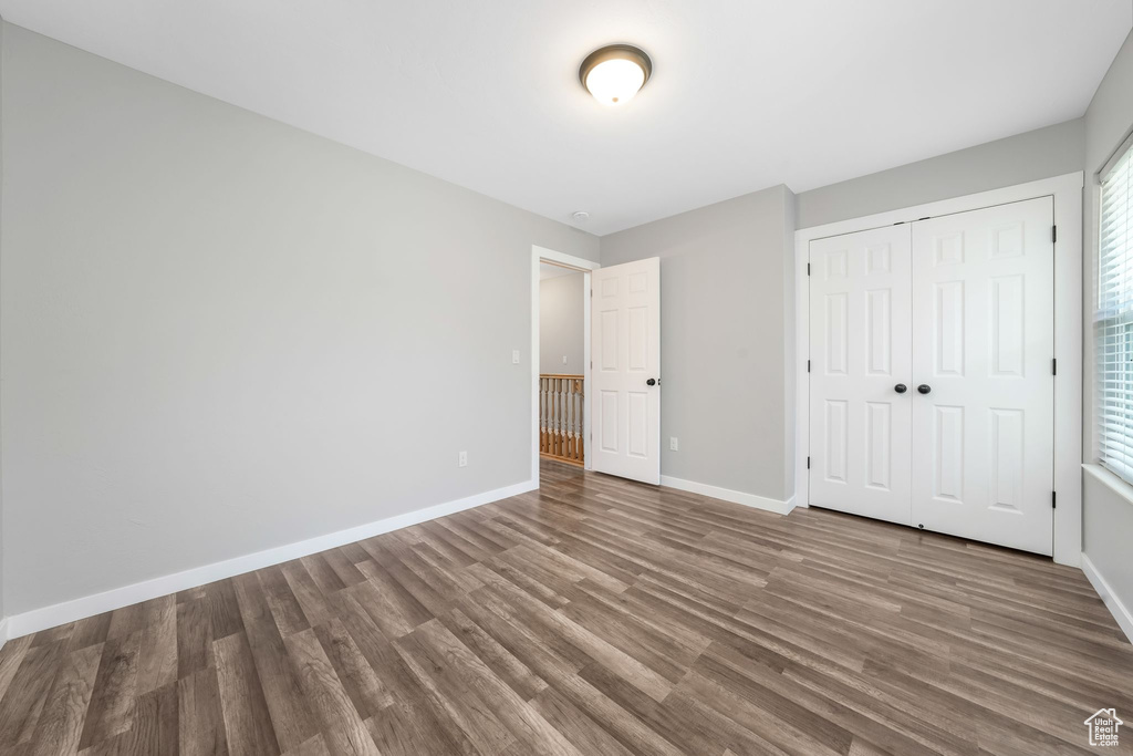 Unfurnished bedroom featuring wood finished floors and a closet