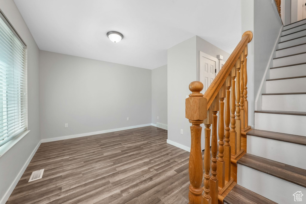 Stairs with wood finished floors and baseboards