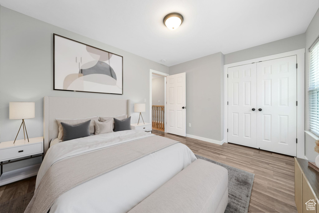Bedroom with wood finished floors and a closet