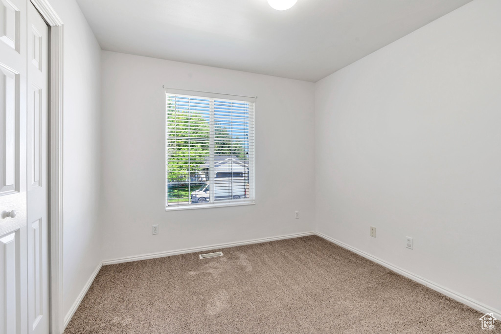 Carpeted empty room with baseboards