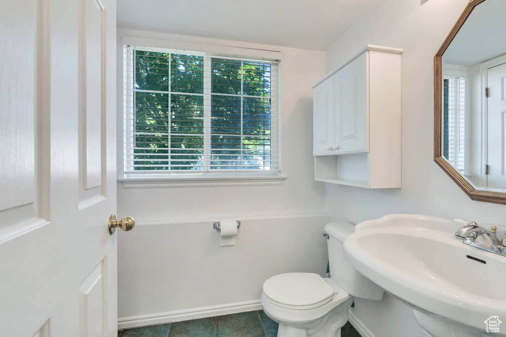 Half bathroom with a sink and tile patterned flooring