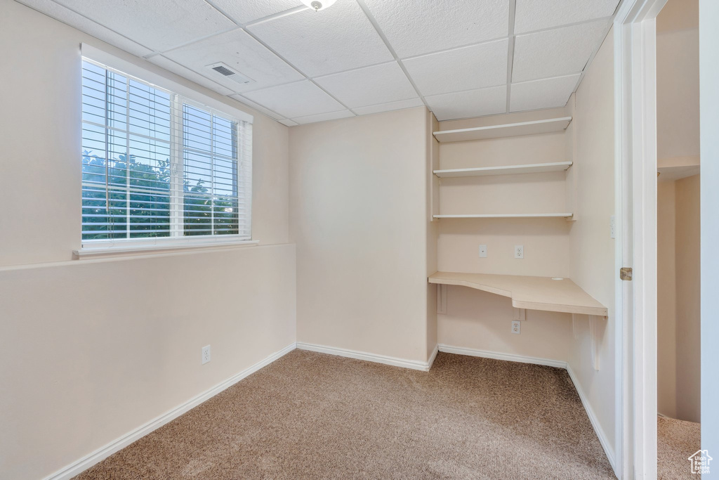 Interior space featuring carpet and a paneled ceiling
