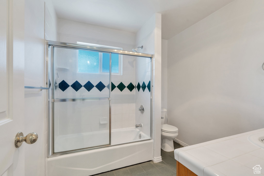 Bathroom featuring tile patterned floors, vanity, and enclosed tub / shower combo
