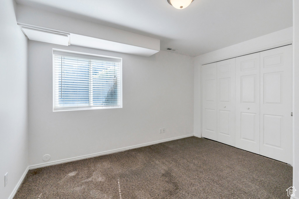 Unfurnished bedroom with carpet flooring and a closet