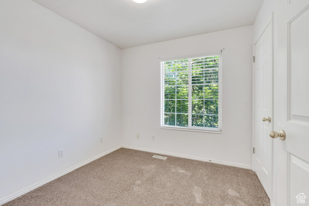 Carpeted empty room with baseboards