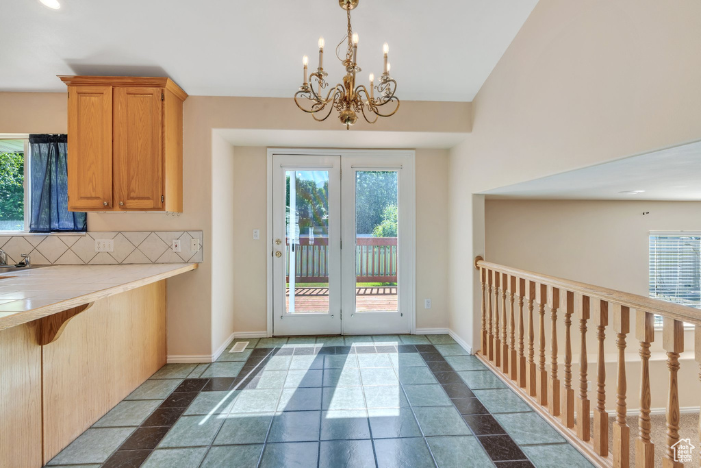 Doorway with a chandelier and baseboards