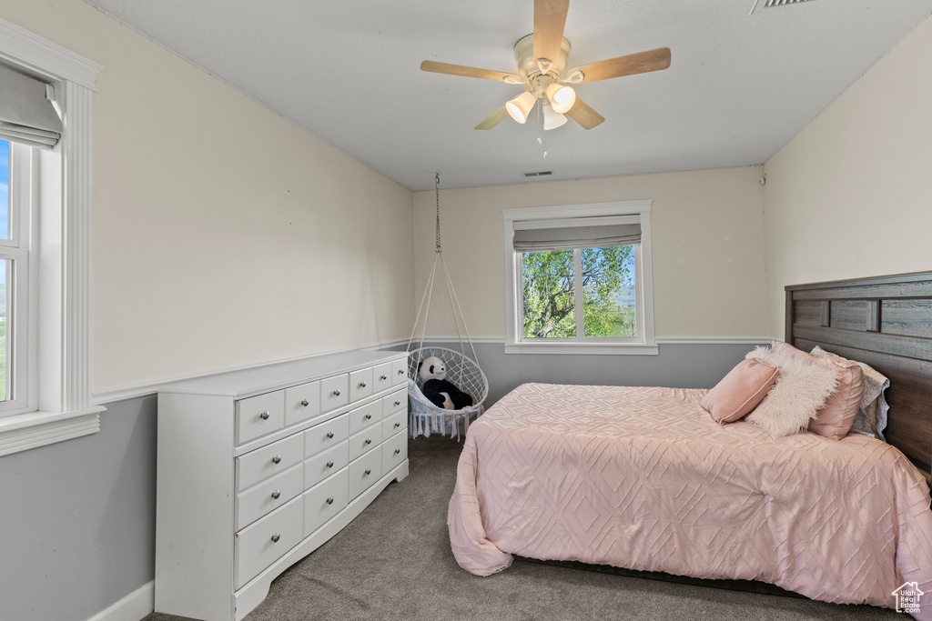 Carpeted bedroom with a ceiling fan