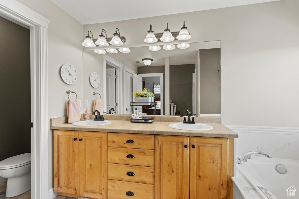 Full bathroom featuring double vanity and a garden tub