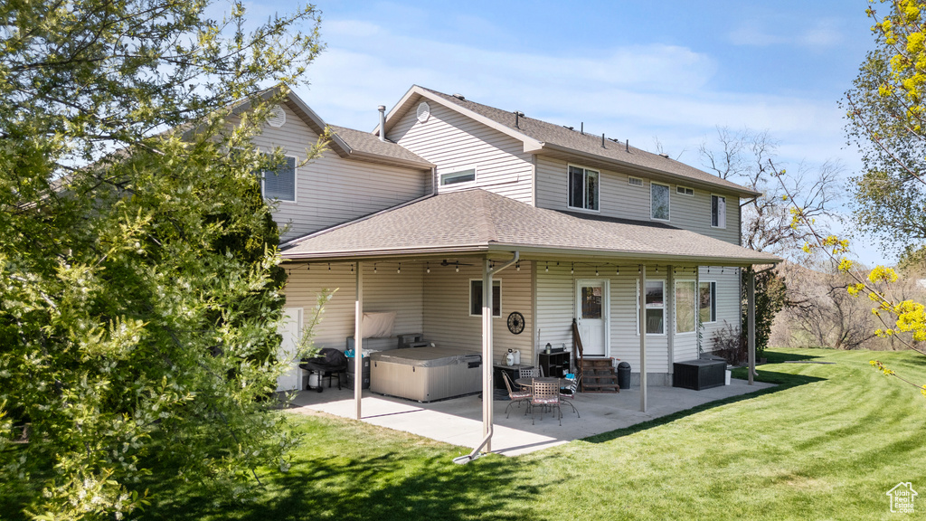 Back of property with a patio, a lawn, entry steps, and a shingled roof