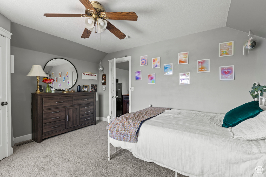 Bedroom featuring vaulted ceiling, light colored carpet, and a ceiling fan