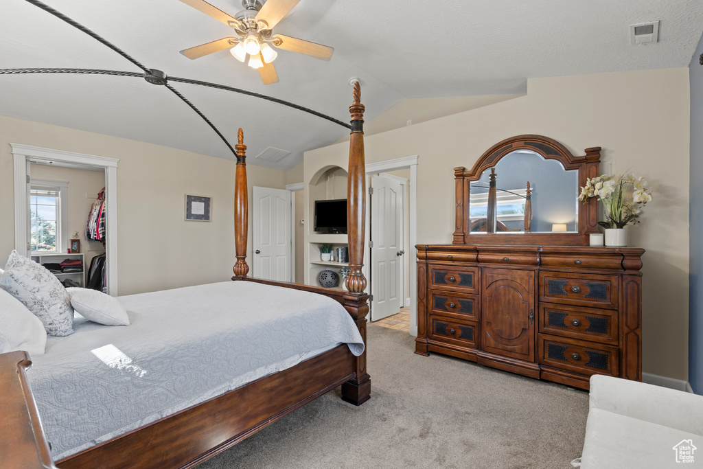 Bedroom featuring carpet, vaulted ceiling, and ceiling fan