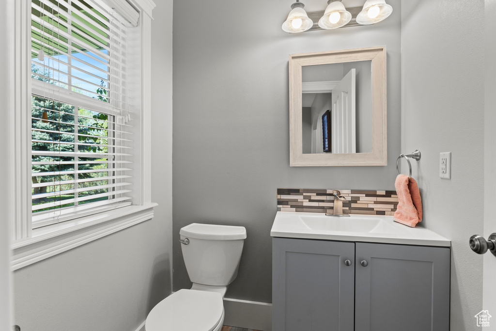 Half bathroom with backsplash and vanity