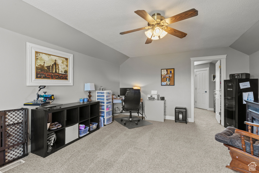 Carpeted office space with vaulted ceiling and ceiling fan