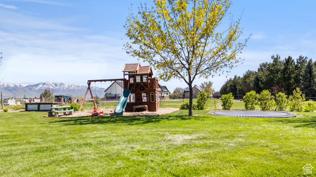 View of jungle gym featuring a yard and a mountain view