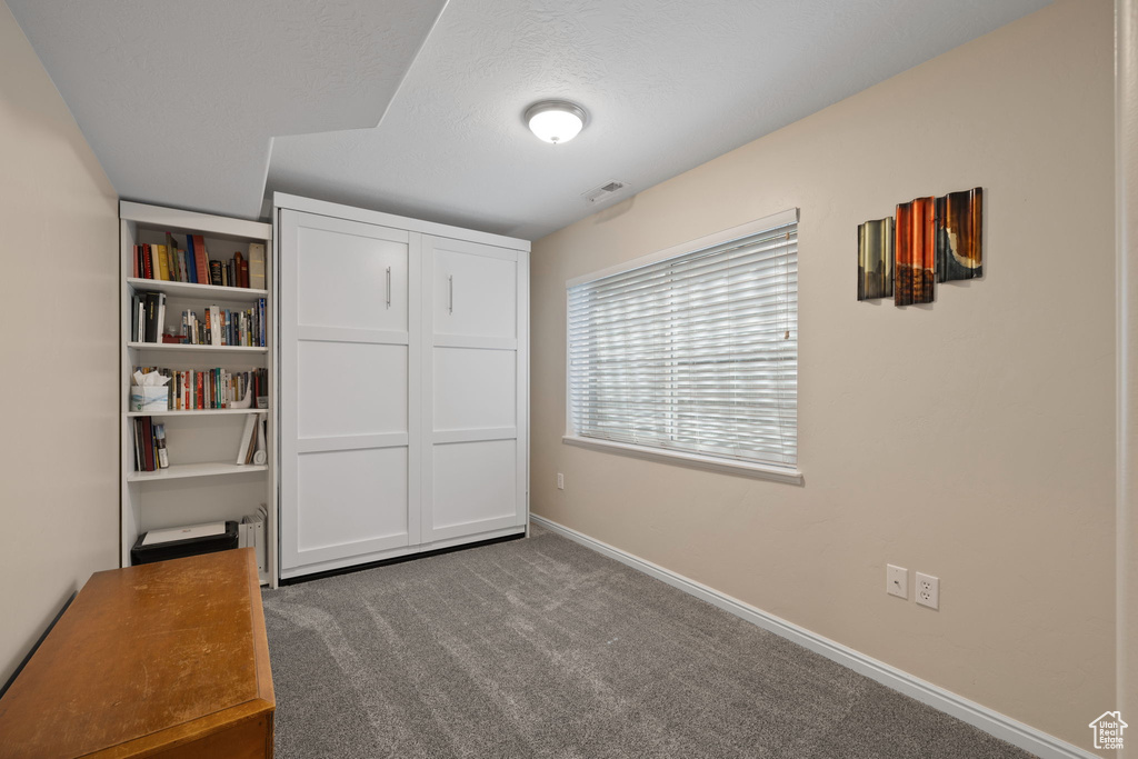 Unfurnished bedroom featuring carpet and baseboards