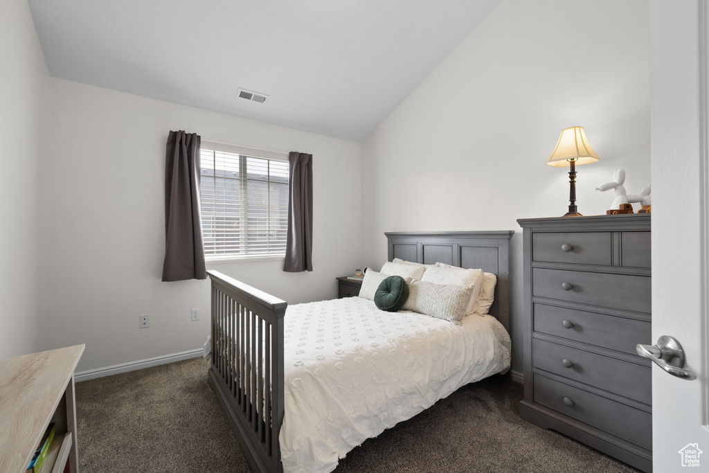 Bedroom featuring dark carpet and vaulted ceiling