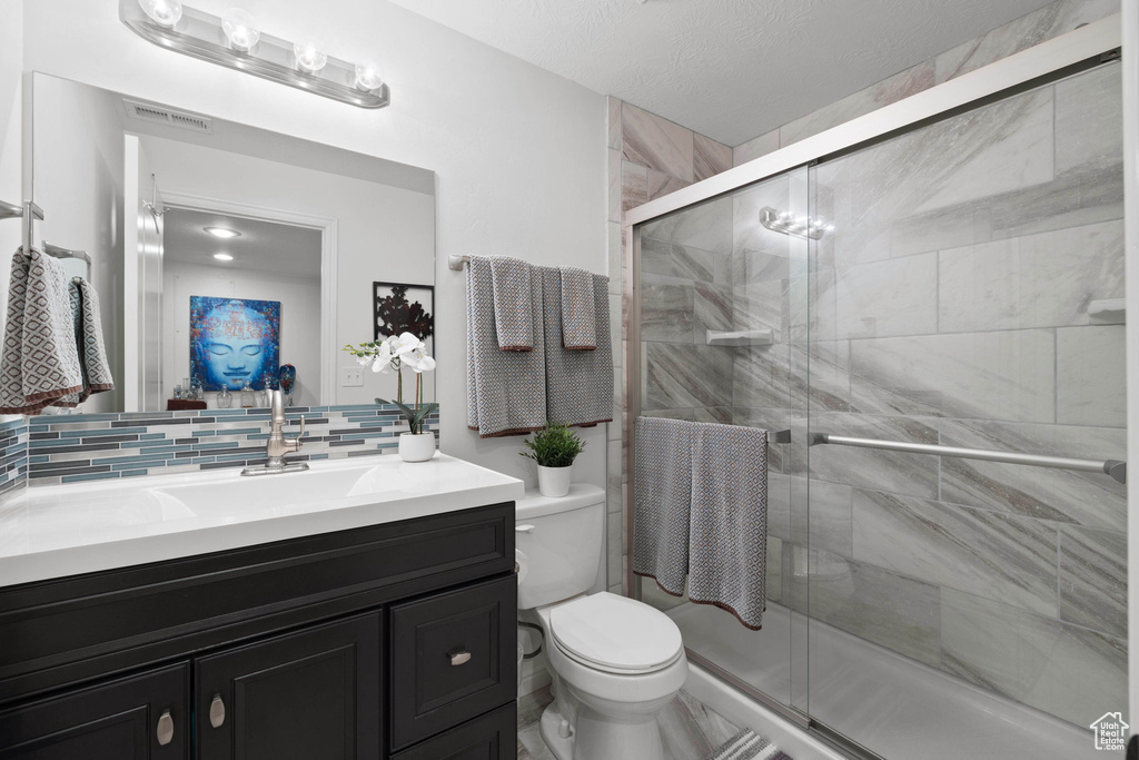 Bathroom featuring vanity, tasteful backsplash, and a stall shower