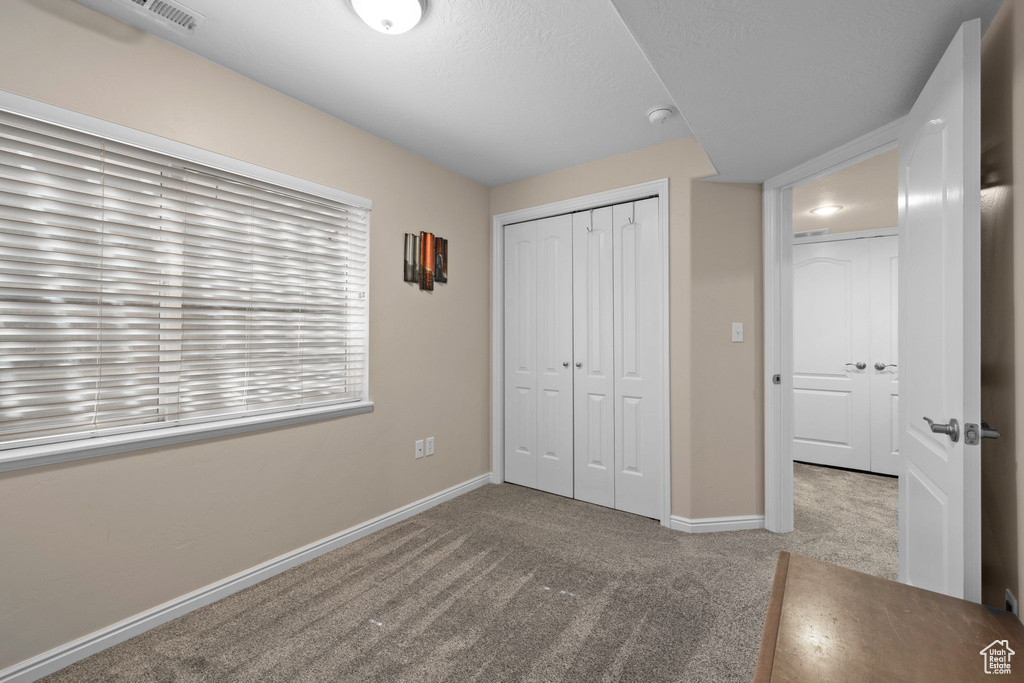 Unfurnished bedroom with carpet floors and a closet